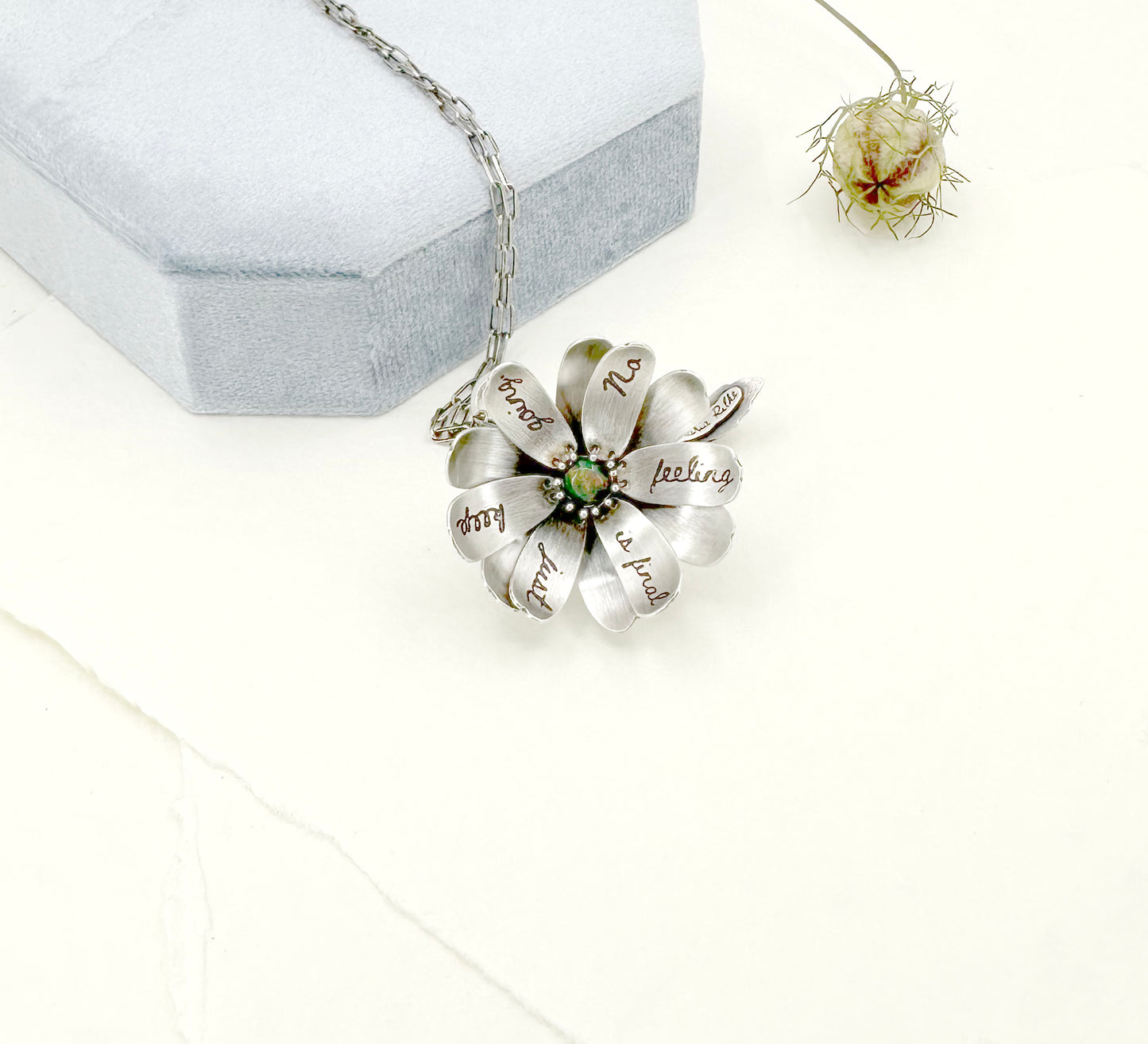 "Let everything happen..." kinetic flower with Rilke quote in sterling silver with black opal.