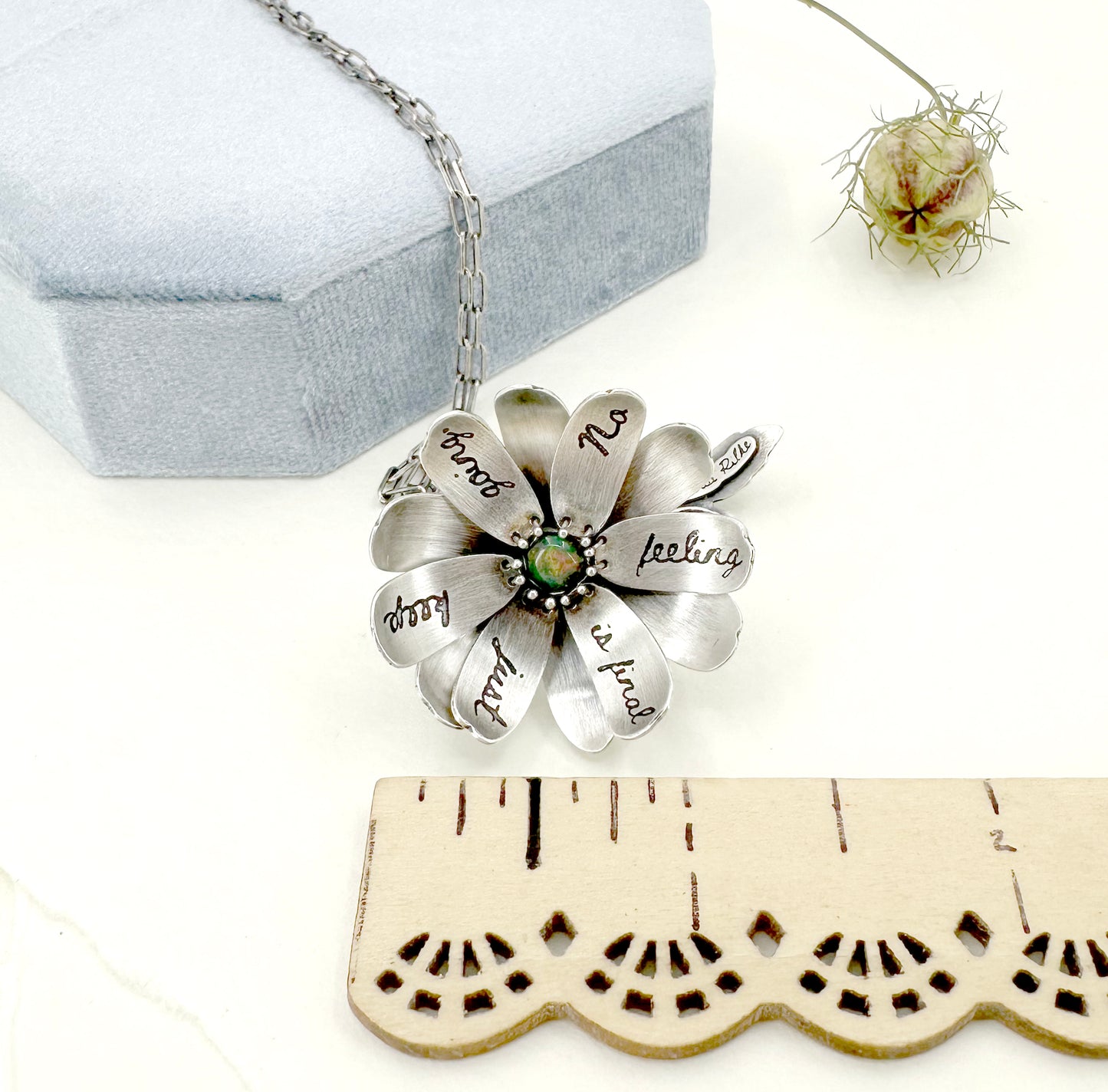 "Let everything happen..." kinetic flower with Rilke quote in sterling silver with black opal.