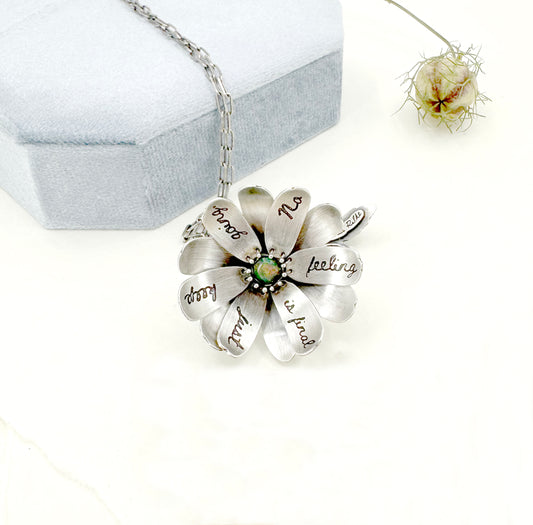 "Let everything happen..." kinetic flower with Rilke quote in sterling silver with black opal.