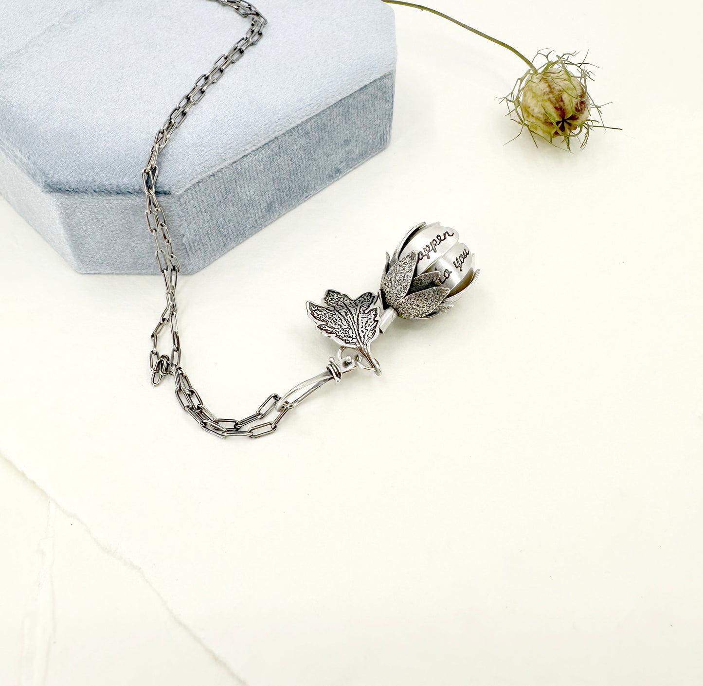 "Let everything happen..." kinetic flower with Rilke quote in sterling silver with black opal.