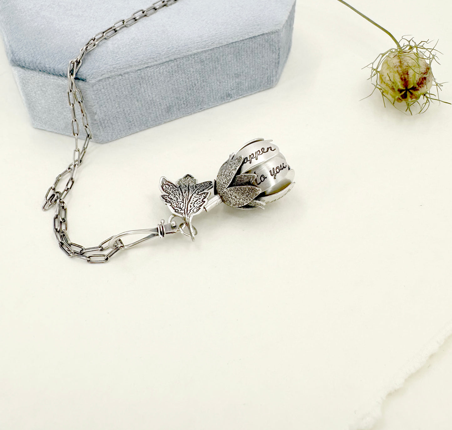 "Let everything happen..." kinetic flower with Rilke quote in sterling silver with black opal.